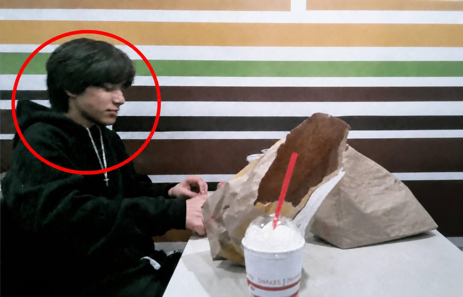 Dom sitting at a table, marked with a red circle